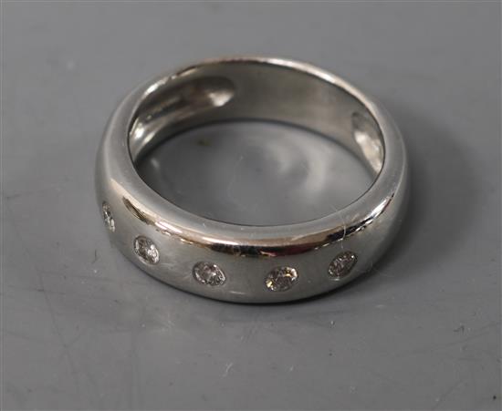 A modern 18ct white gold and five stone gypsy set diamond ring, size K.